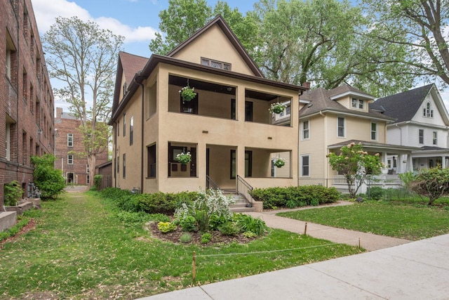 2227 Garfield Ave, Minneapolis, MN 55405 - view of front facade with stucco siding, a front yard, and a balcony