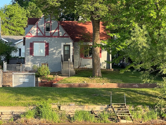 205 Lake Park Blvd, Fairmont, MN 56031 - tudor house featuring entry steps, a front lawn, stucco siding, and an attached garage