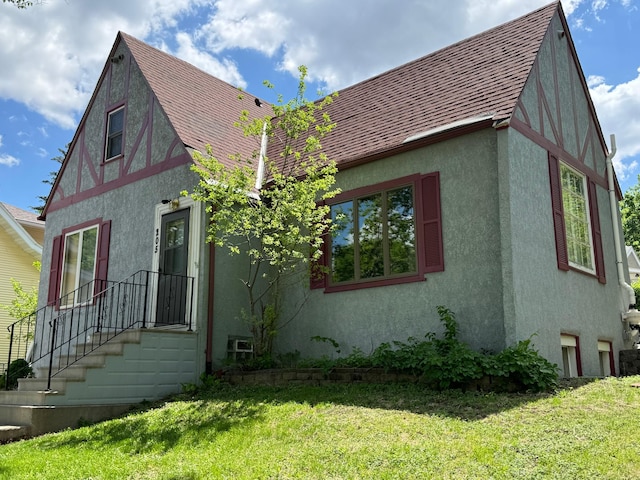 205 Lake Park Blvd, Fairmont, MN 56031 - view of side of property with stucco siding, a shingled roof, and a yard