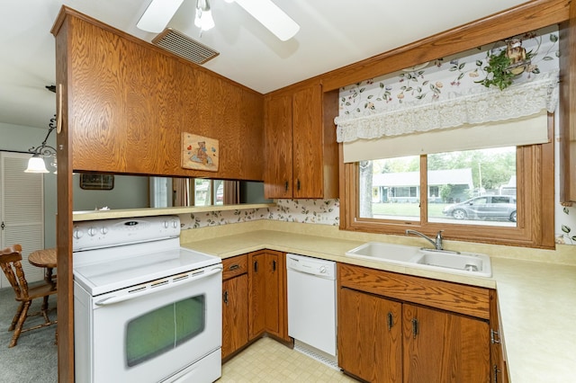 kitchen with white appliances, a sink, light countertops, a ceiling fan, and brown cabinets