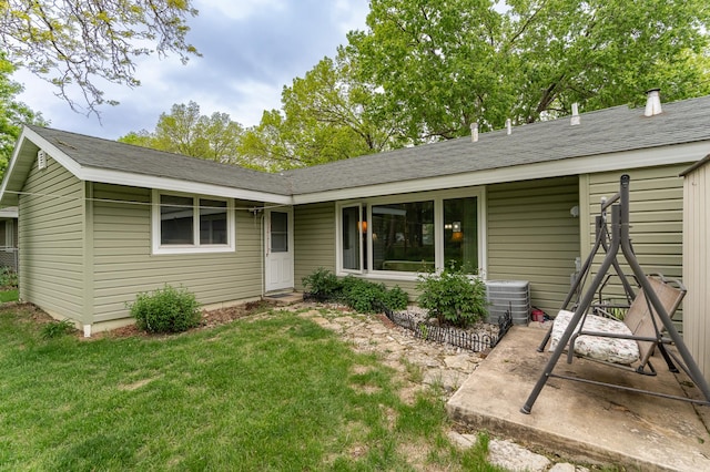 view of front of home with a front yard and central AC
