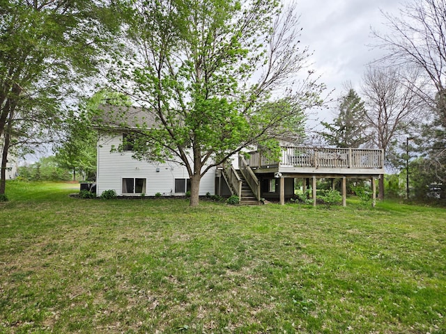 back of house featuring stairs, a deck, and a yard