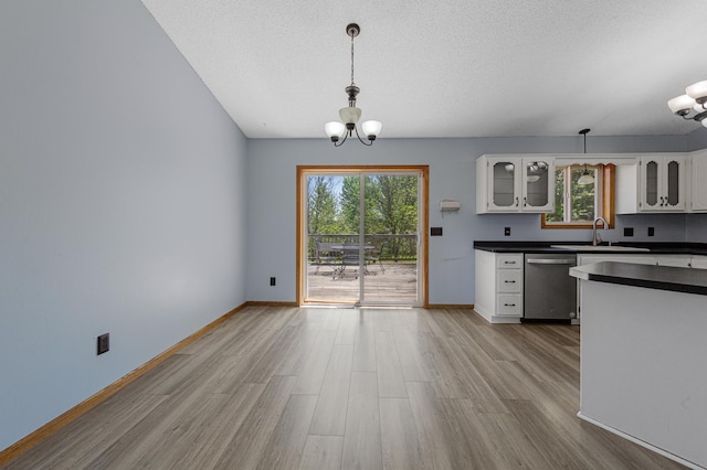 kitchen featuring dishwasher, dark countertops, a chandelier, white cabinetry, and a textured ceiling
