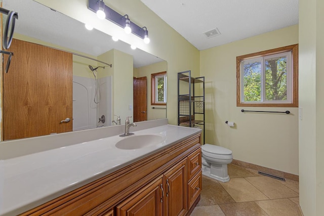 bathroom featuring toilet, vanity, baseboards, a shower, and tile patterned flooring
