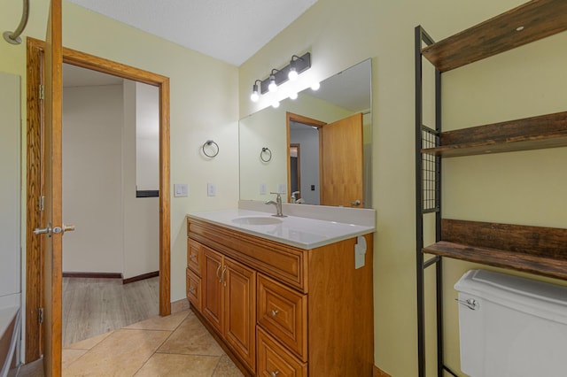 bathroom featuring vanity, toilet, and tile patterned flooring