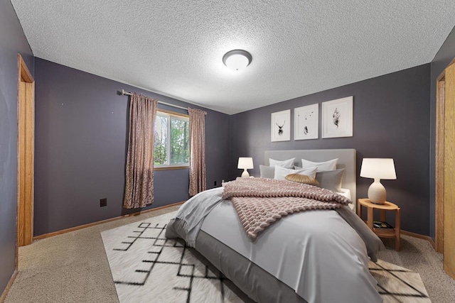 bedroom with baseboards, carpet floors, and a textured ceiling