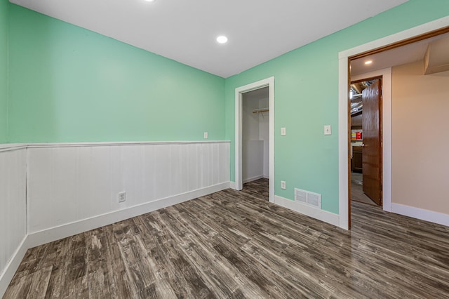 unfurnished bedroom with wood finished floors, recessed lighting, a spacious closet, a closet, and baseboards