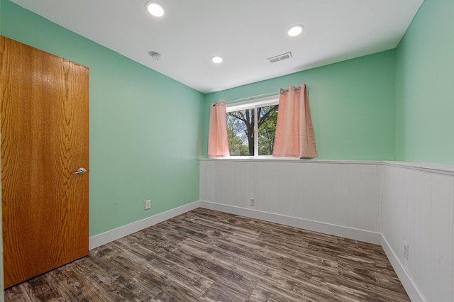 unfurnished room featuring wood finished floors, a wainscoted wall, recessed lighting, and baseboards