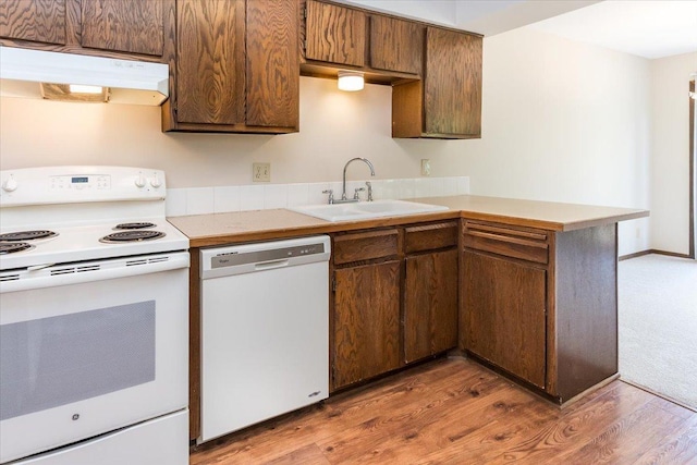 10350 Balsam Ln, Eden Prairie, MN 55347 - kitchen featuring white appliances, under cabinet range hood, a peninsula, light wood-style flooring, and light countertops