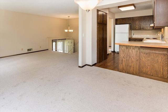 10350 Balsam Ln, Eden Prairie, MN 55347 - kitchen featuring freestanding refrigerator, dark carpet, a chandelier, light countertops, and dark brown cabinets