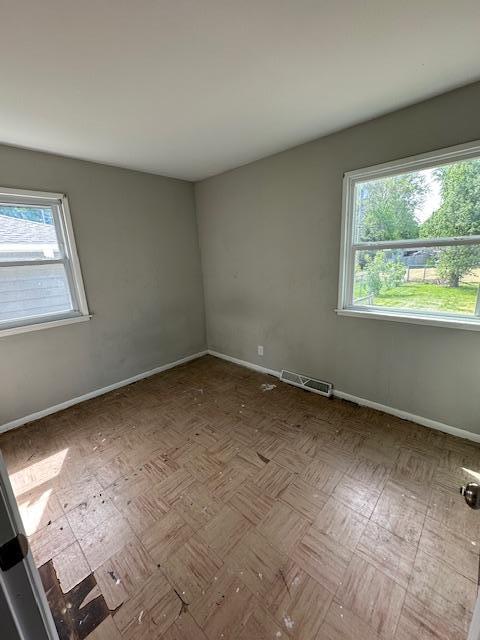 spare room with plenty of natural light and baseboards