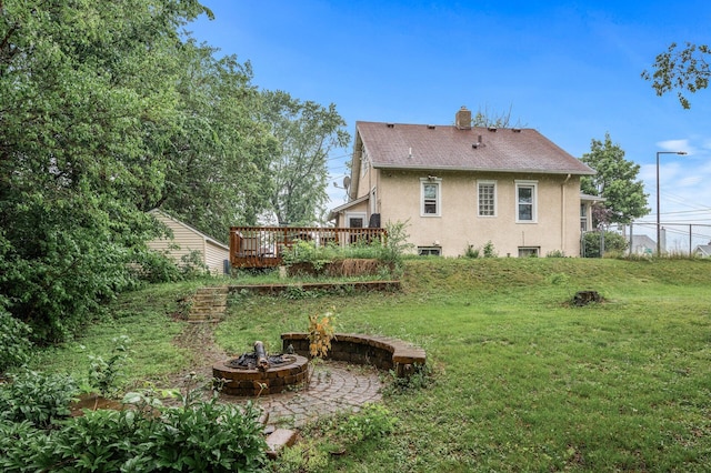 48 Jessamine Ave E, Saint Paul, MN 55117 - back of house featuring a fire pit, stucco siding, a yard, a deck, and a chimney