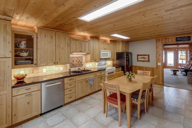 kitchen with white appliances, light brown cabinets, wooden walls, dark countertops, and wooden ceiling