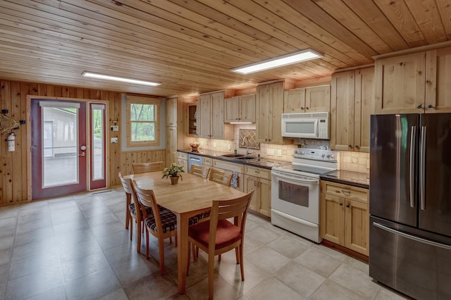 kitchen with stainless steel appliances, dark countertops, a sink, wooden ceiling, and backsplash