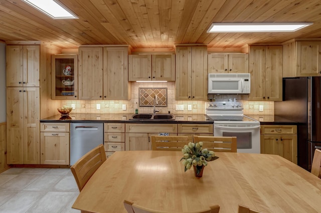 kitchen featuring stainless steel appliances, a sink, light brown cabinetry, decorative backsplash, and wood ceiling
