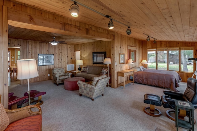 carpeted bedroom with rail lighting, wooden ceiling, and wooden walls