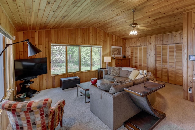 living area featuring vaulted ceiling, carpet floors, wooden ceiling, wood walls, and ceiling fan