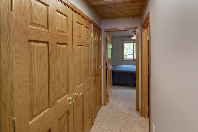 corridor featuring light carpet and wood ceiling