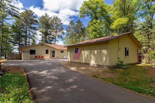 single story home with driveway and roof with shingles