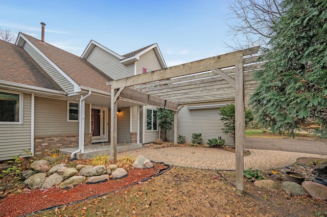 2970 Western Ave N, Roseville, MN 55113 - back of property with roof with shingles, a pergola, brick siding, and covered porch
