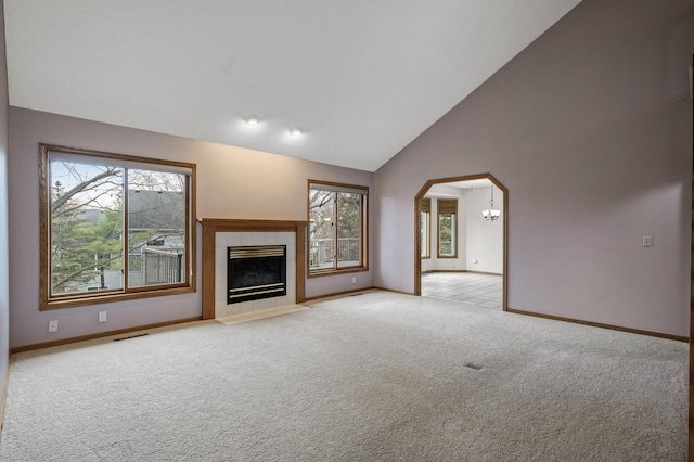 2970 Western Ave N, Roseville, MN 55113 - unfurnished living room featuring light colored carpet, baseboards, a chandelier, arched walkways, and high vaulted ceiling