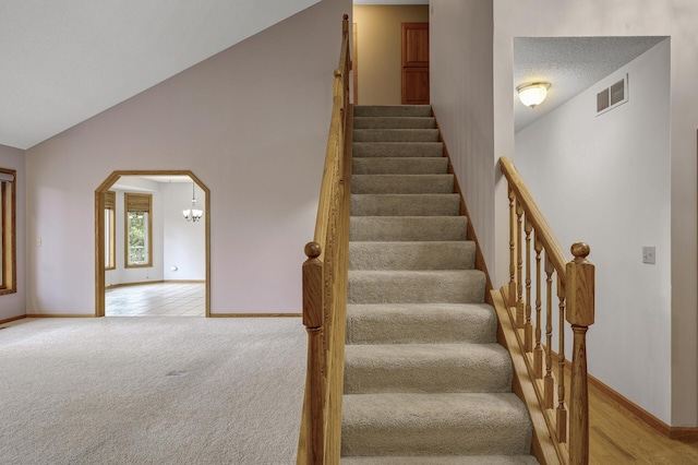 2970 Western Ave N, Roseville, MN 55113 - staircase with baseboards, arched walkways, lofted ceiling, and a chandelier