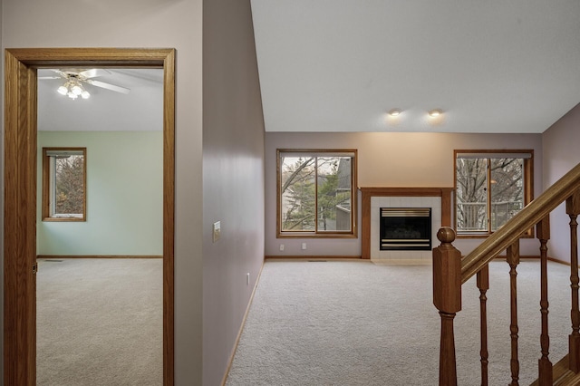 2970 Western Ave N, Roseville, MN 55113 - unfurnished living room featuring carpet floors, a tile fireplace, ceiling fan, healthy amount of natural light, and vaulted ceiling
