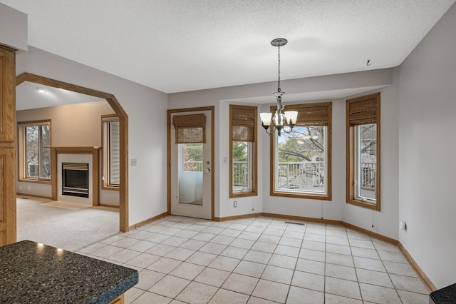 2970 Western Ave N, Roseville, MN 55113 - unfurnished dining area with plenty of natural light, a chandelier, a textured ceiling, baseboards, and a fireplace