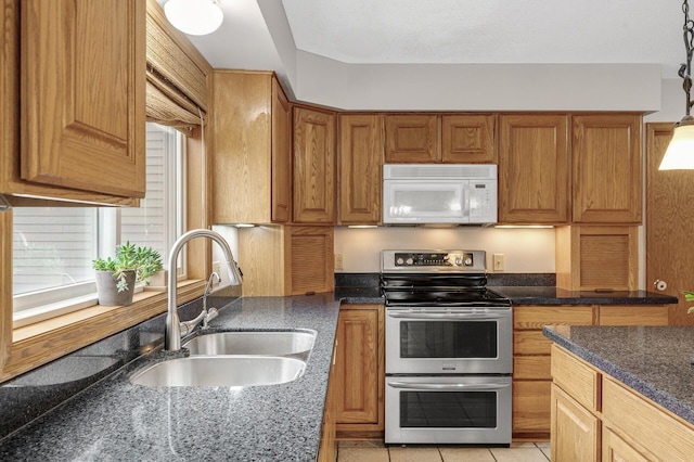 2970 Western Ave N, Roseville, MN 55113 - kitchen with range with two ovens, white microwave, a sink, dark stone countertops, and brown cabinetry
