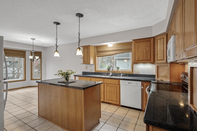 2970 Western Ave N, Roseville, MN 55113 - kitchen featuring white appliances, a sink, a kitchen island, light tile patterned flooring, and decorative light fixtures
