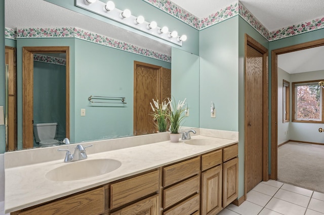2970 Western Ave N, Roseville, MN 55113 - full bathroom with a textured ceiling, tile patterned floors, double vanity, and toilet
