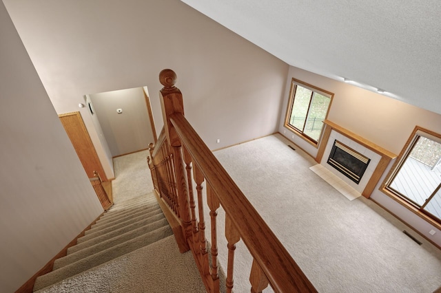 2970 Western Ave N, Roseville, MN 55113 - stairway featuring carpet flooring, a tile fireplace, and a textured ceiling