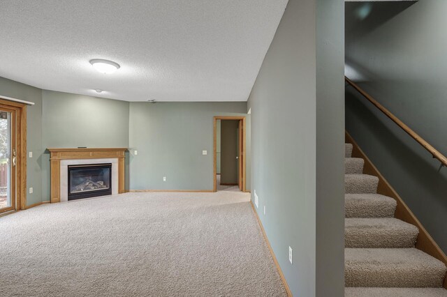 2970 Western Ave N, Roseville, MN 55113 - unfurnished living room featuring carpet flooring, a glass covered fireplace, stairway, baseboards, and a textured ceiling
