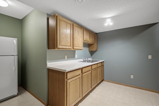2970 Western Ave N, Roseville, MN 55113 - kitchen featuring freestanding refrigerator, a sink, a textured ceiling, light countertops, and light flooring