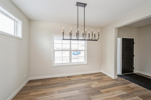 869 Greywood Blvd SW, Delano, MN 55328 - unfurnished dining area featuring a chandelier, wood finished floors, and baseboards