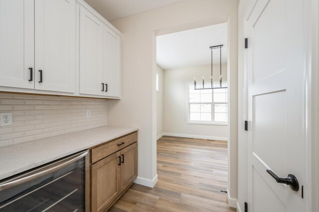 869 Greywood Blvd SW, Delano, MN 55328 - bar featuring wine cooler, tasteful backsplash, light wood-type flooring, and baseboards