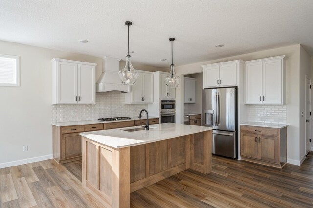 869 Greywood Blvd SW, Delano, MN 55328 - kitchen featuring stainless steel appliances, premium range hood, a sink, dark wood-style flooring, and tasteful backsplash