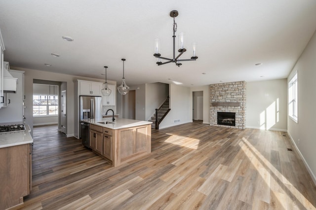 869 Greywood Blvd SW, Delano, MN 55328 - kitchen featuring appliances with stainless steel finishes, a chandelier, wood finished floors, baseboards, and a sink