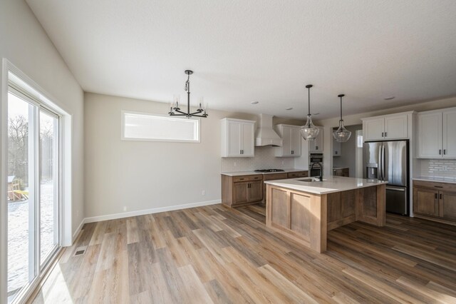 869 Greywood Blvd SW, Delano, MN 55328 - kitchen with stainless steel fridge with ice dispenser, custom exhaust hood, backsplash, and gas cooktop