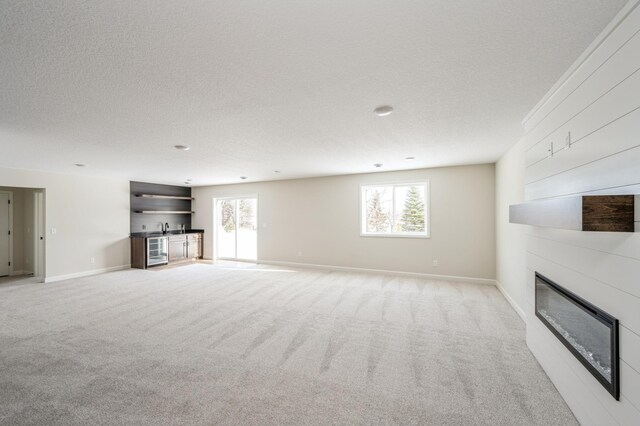 869 Greywood Blvd SW, Delano, MN 55328 - unfurnished living room with a fireplace, healthy amount of natural light, light colored carpet, and a textured ceiling