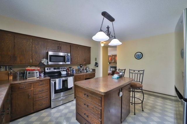 912 State 84 SW, Pine River, MN 56474 - kitchen with stainless steel appliances, light flooring, a breakfast bar area, a kitchen island, and pendant lighting