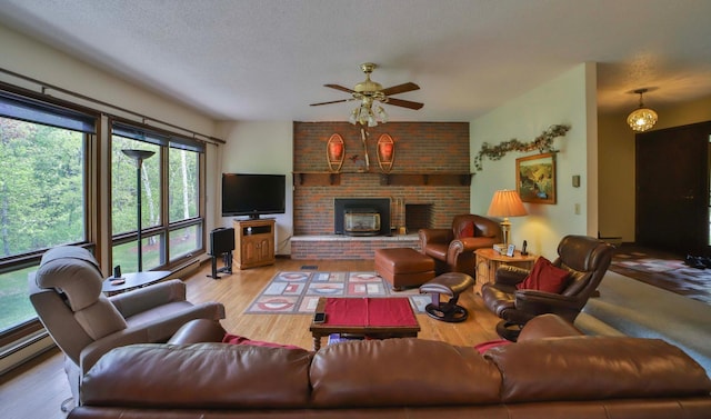912 State 84 SW, Pine River, MN 56474 - living room with a baseboard radiator, a ceiling fan, wood finished floors, a brick fireplace, and a textured ceiling