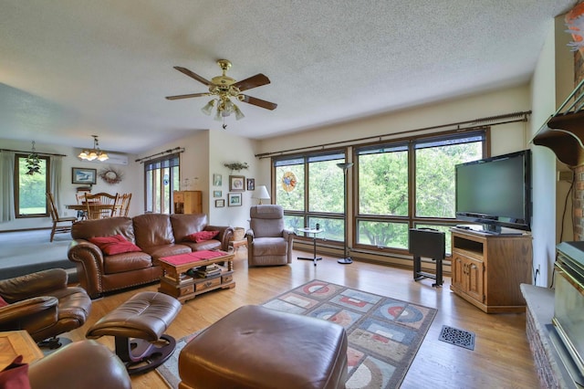 912 State 84 SW, Pine River, MN 56474 - living room with a textured ceiling, light wood-style flooring, a ceiling fan, and a chandelier