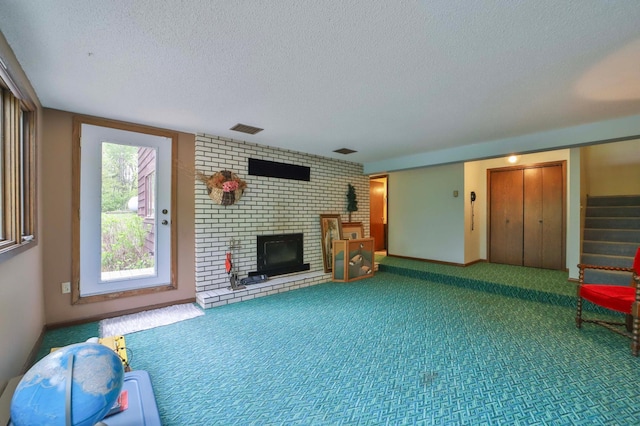 912 State 84 SW, Pine River, MN 56474 - unfurnished living room featuring a textured ceiling, a fireplace, carpet, and stairway