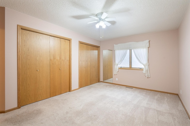 1930 Westridge Cir, Stillwater, MN 55082 - unfurnished bedroom featuring two closets, carpet floors, baseboards, a textured ceiling, and ceiling fan