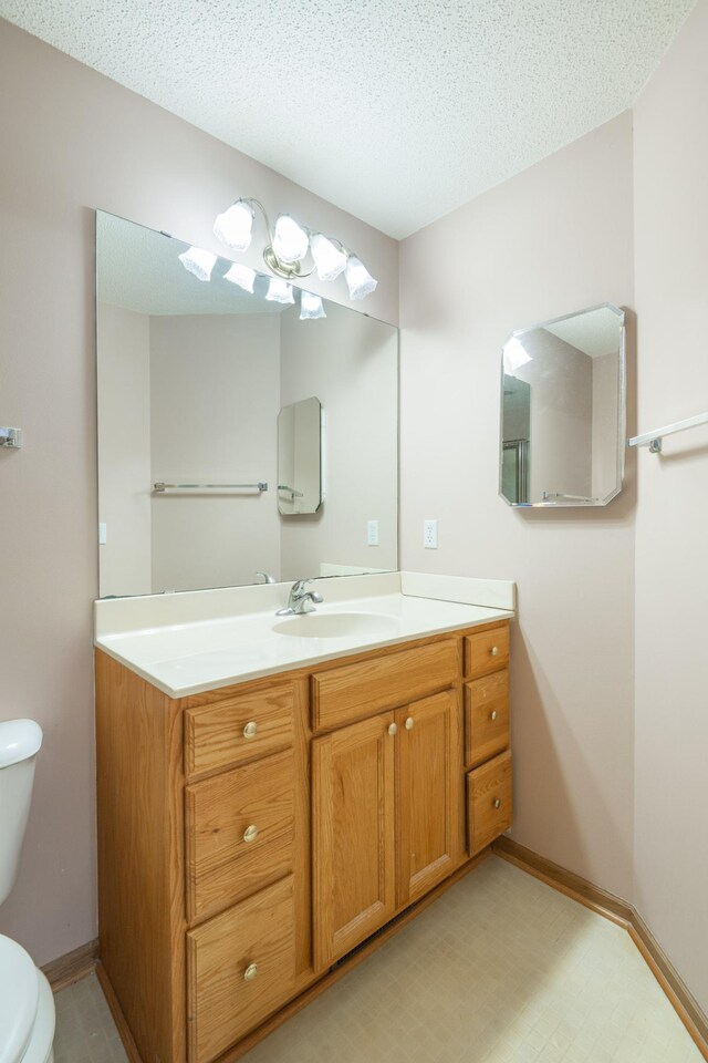 1930 Westridge Cir, Stillwater, MN 55082 - bathroom with toilet, vanity, baseboards, and a textured ceiling