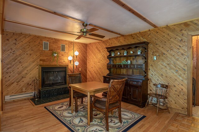 224 Norman Point Rd NW, Longville, MN 56655 - dining area featuring a baseboard heating unit, a ceiling fan, beam ceiling, wood walls, and light wood-type flooring