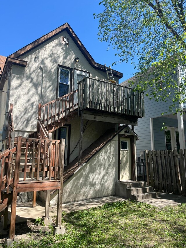 1030 28th Ave NE, Minneapolis, MN 55418 - rear view of property with a wooden deck, fence, stairs, and stucco siding
