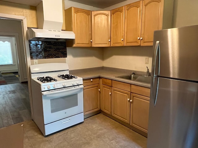 1030 28th Ave NE, Minneapolis, MN 55418 - kitchen with freestanding refrigerator, white range with gas stovetop, extractor fan, a sink, and decorative backsplash