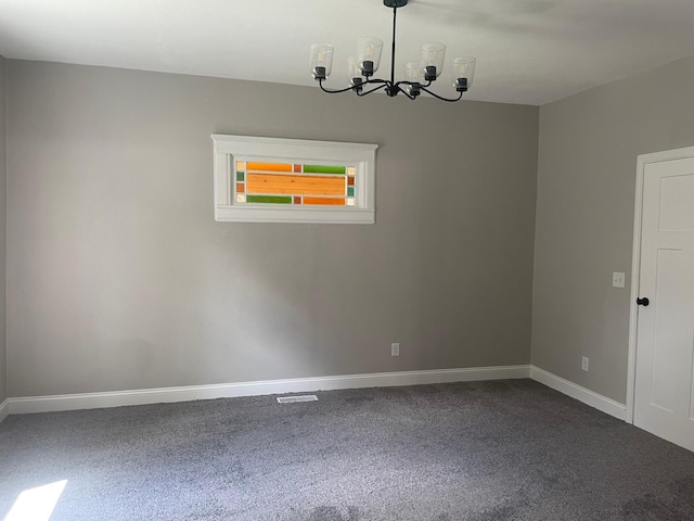 309 4th St, Marshall, MN 56258 - empty room featuring a chandelier, dark colored carpet, and baseboards